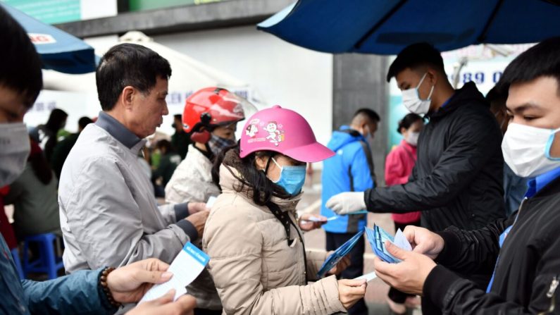 Des Vietnamiens font la queue pour recevoir gratuitement des masques de protection dans un centre de distribution de fortune, en raison de l'épidémie du nouveau coronavirus, à Hanoi, le 8 février 2020. (Manan Vatsyayana/AFP/Getty Images)
