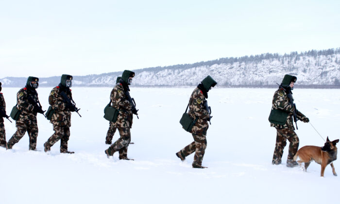 Les gardes-frontières de la police paramilitaire chinoise s'entraînent dans la neige dans le canton de Mohe, dans la province du Heilongjiang, au nord-est de la Chine, à la frontière avec la Russie, le 12 décembre 2016. Mohe est le point le plus au nord de la Chine, avec un climat subarctique où les températures tombent jusqu’à -36 degrés Celsius. (STR/AFP via Getty Images)