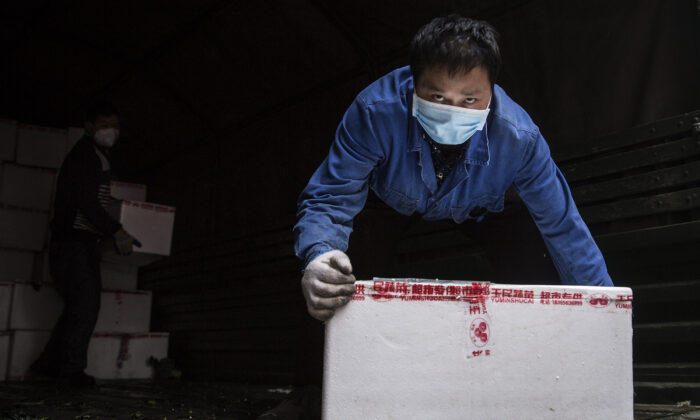 Un employé porte un masque de protection lorsqu'il transporte des légumes dans un camion à l'hôpital de Wuhan, en Chine, le 10 février 2020. (Getty Images)