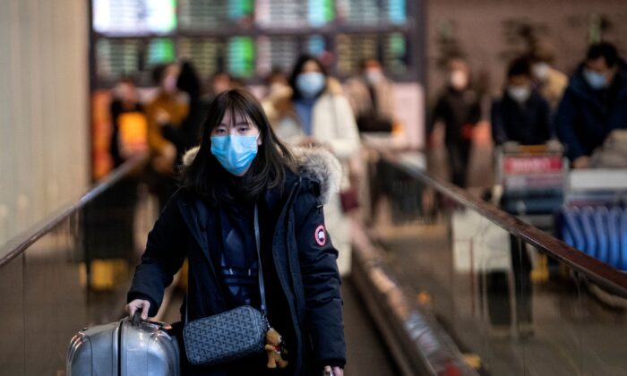 Une passagère portant un masque de protection se présente à son arrivée à l'aéroport international de Pékin, le 2 février 2020. (Noel Celis/AFP via Getty Images)