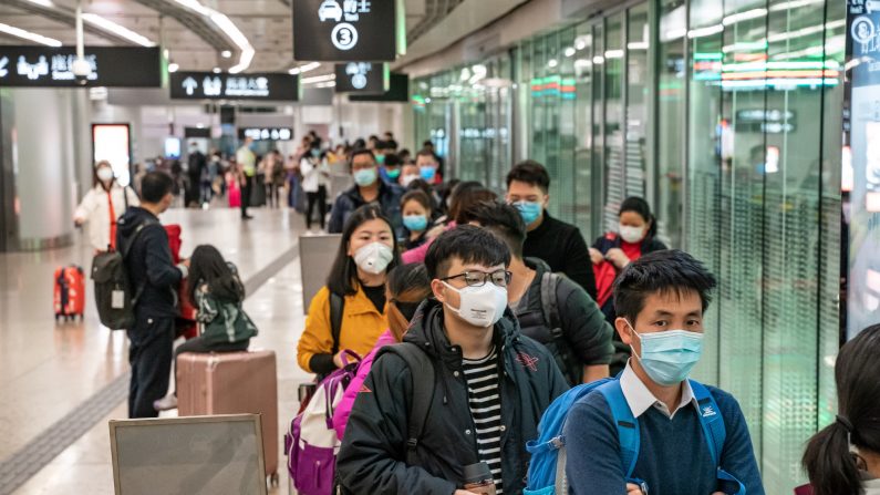 Des voyageurs portant des masques de protection font la queue pour les taxis après leur arrivée à la gare ferroviaire à grande vitesse de Hong Kong, le 29 janvier 2020. (Anthony Kwan/Getty Images)