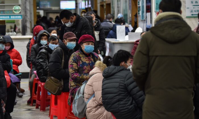 Des personnes portant des masques font la queue devant l'hôpital de la Croix-Rouge de Wuhan, le 24 janvier 2020. (Hector Retamal/AFP via Getty Images)