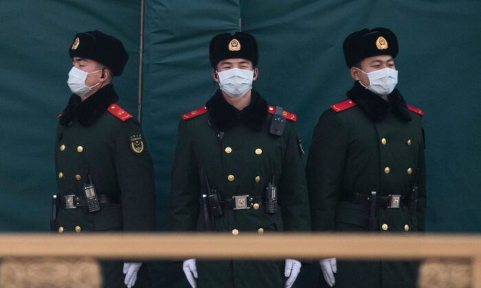 Des policiers chinois portent des masques de protection alors qu'ils montent la garde sur une route principale à Pékin, en Chine, le 31 janvier 2020. (Kevin Frayer/Getty Images)