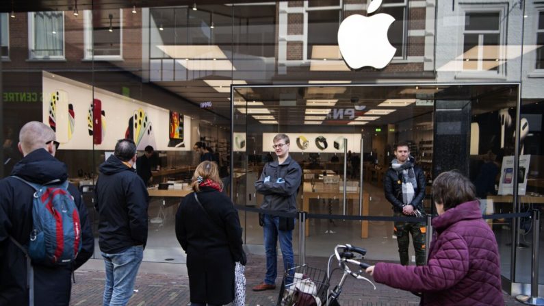 Des gens se tiennent devant un magasin Apple à Haarlem, aux Pays-Bas, le 14 mars 2020. (Olaf Kraak/AFP via Getty Images)