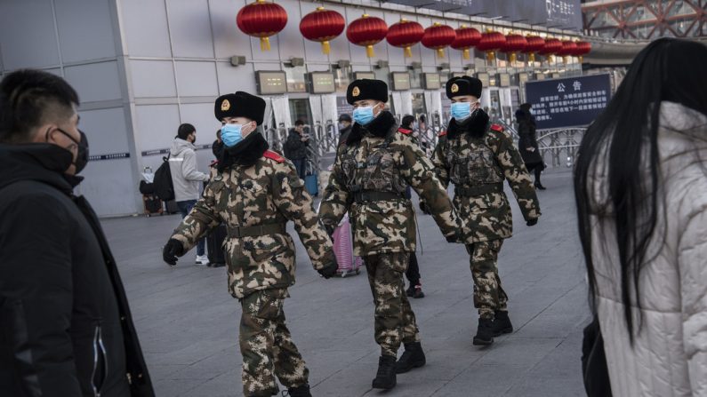 Des policiers chinois portent des masques de protection lors de leur patrouille avant le festival annuel du printemps dans une gare de Pékin, le 23 janvier 2020. (Kevin Frayer/Getty Images)