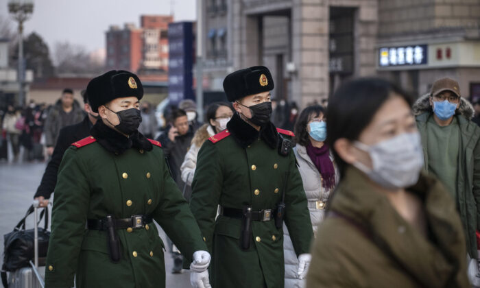 Les policiers chinois portent des masques de protection lorsqu'ils patrouillent dans la gare de Pékin avant le Festival annuel du printemps, le 22 janvier 2020, à Pékin. (Kevin Frayer/Getty Images)