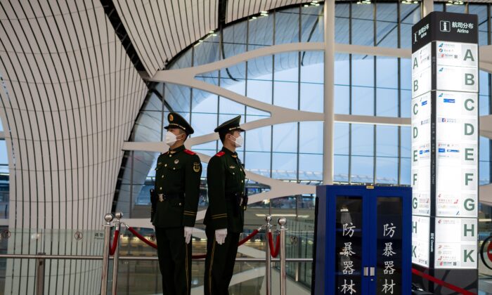 Des agents de la police paramilitaire chinoise portant des masques de protection sécurisent une partie de l'aéroport international de Daxing à Pékin, le 14 février 2020. (Nicolas Asfouri/AFP via Getty Images)