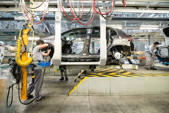 Des employés de PSA travaillent sur une voiture sur la chaîne de montage de l'usine du constructeur automobile français PSA Peugeot Citroën, à Mulhouse.   (Photo : SEBASTIEN BOZON/AFP via Getty Images)