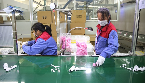 -Illustration- Cette photo prise le 10 février 2020 montre des travailleurs fabriquant des thermomètres dans une usine de la province chinoise du Shandong oriental. Photo par STR / AFP via Getty Images.
