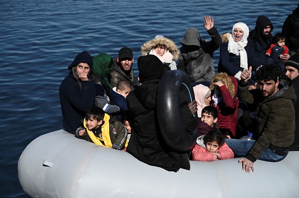 Des migrants se trouvent sur un bateau gonflable alors que les résidents locaux les empêchent de débarquer sur l'île de Lesbos, le 1er mars 2020. (Photo : ARIS MESSINIS/AFP via Getty Images)