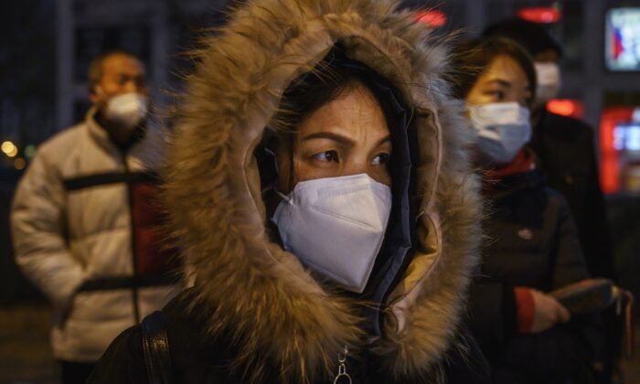 Les employés de bureau chinois portent des masques de protection lorsqu'ils font la queue pour prendre le bus après avoir quitté leur travail à Pékin, en Chine, le 2 mars 2020. (Kevin Frayer/Getty Images)