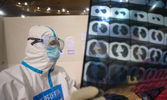 Un médecin examine la radiographie d'un patient dans un hôpital temporaire à Wuhan, en Chine, le 5 mars 2020. (STR/AFP via Getty Images)