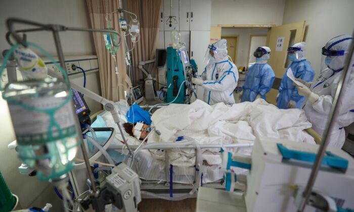 Le 6 mars 2020, le personnel médical examine un patient atteint du coronavirus COVID-19 à l'hôpital de la Croix-Rouge à Wuhan, en Chine. (STR/AFP via Getty Images)