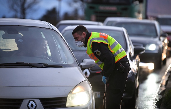 Un officier de police allemand contrôle des véhicules à la frontière entre les villes de Strasbourg et Kehl le 12 mars 2020. (PATRICK HERTZOG/AFP via Getty Images)