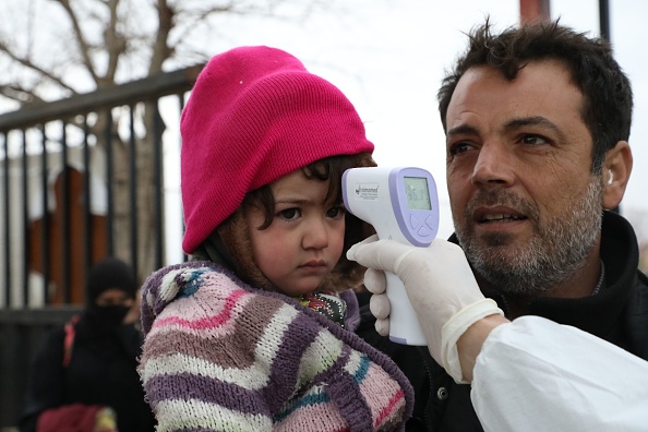 Les personnes traversant la Turquie vers le nord de la Syrie traversent le poste frontalier de Bab al-Salama et sont contrôlées pour le coronavirus le 13 mars 2020. La Syrie n'a pas encore confirmé de cas de coronavirus, mais ses "systèmes de santé fragiles n'ont peut-être pas la capacité de détecter et de répondre" à une épidémie, a déclaré le porte-parole de l'Organisation mondiale de la santé Hedinn Halldorsson. Photo de NAYEF AL-ABOUD / AFP via Getty Images.