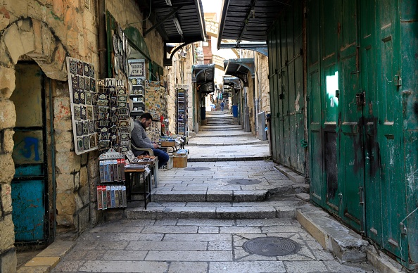 -Un vendeur de souvenirs attend des clients dans la vieille ville de Jérusalem quasiment vide le 16 mars 2020. Photo par Emmanuel DUNAND / AFP via Getty Images.
