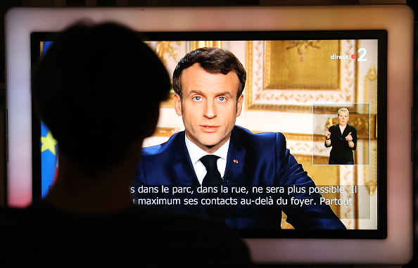 Le Président Emmanuel Macron vu sur un écran de télévision lors du discours télévisé à la nation sur l'épidémie de Covid-19, le 16 mars 2020, à Paris. (Photo : LUDOVIC MARIN/AFP via Getty Images)