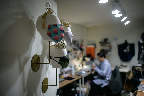-Le créateur de mode de boutique Paul Park travaille sur une machine à coudre pour créer un masque facial, dans son atelier de Séoul le 19 mars 2020. Photo par ED JONES / AFP via Getty Images.