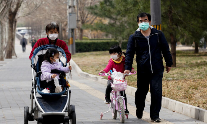 Une famille chinoise portant un masque de protection dans un parc à Pékin, en Chine, le 19 mars 2020. (Lintao Zhang/Getty Images)