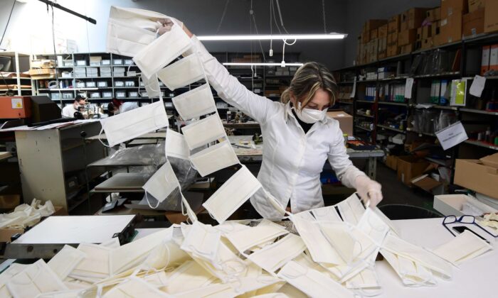Une employée vérifie les masques chirurgicaux dans un atelier de cuir transformé en fabrique de masques, près de Vigevano, en Lombardie, en Italie, le 19 mars 2020. (Miguel Medina/AFP via Getty Images)