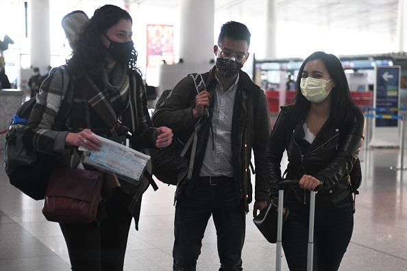-Les journalistes du Wall Street Journal Julie Wernau, Stu Woo et Stephanie Yang traversent l'aéroport de Pékin avant de partir le 28 mars 2020. L'une des plus grandes répressions du gouvernement communiste contre la presse étrangère et intensifiant une âpre dispute sur les libertés des médias. Photo de GREG BAKER / AFP via Getty Images.