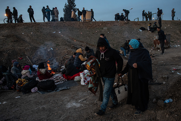 Les réfugiés et les migrants se réchauffent près d'un feu alors qu'ils tentent d'entrer en Grèce depuis la Turquie le 01 mars 2020 à Edirne, en Turquie. (Photo : Burak Kara/Getty Images)