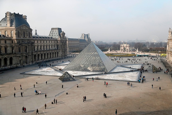 -Les visiteurs marchent autour de la pyramide du musée du Louvre à Paris, le 18 février 2017. Photo FRANCOIS GUILLOT / AFP via Getty Images.