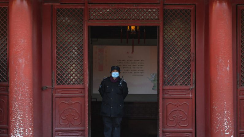 Un agent de sécurité porte un masque facial au Palais impérial lors de sa réouverture au public à Shenyang, en Chine, le 17 mars 2020. (STR/AFP via Getty Images)