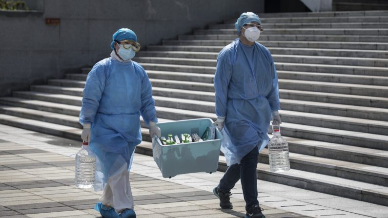 Des travailleurs de la santé portent une boîte à Wuhan, dans la province de Hubei, en Chine, le 10 mars 2020. (Stringer/Getty Images)