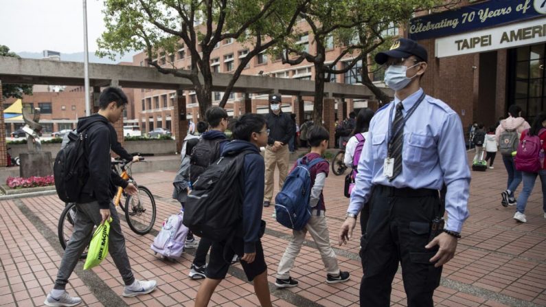 Les élèves entrent à l'école américaine de Taipei, à Taïwan, le 18 mars 2020. Taïwan, Singapour et Hong Kong ont connu plus de succès dans la lutte contre la pandémie COVID-19 que d'autres territoires. (Paula Bronstein/Getty Images) 
