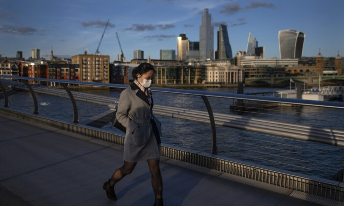 Une femme traverse le Millennium Bridge en portant un masque de protection à Londres le 16 mars 2020. (Justin Setterfield/Getty Images)