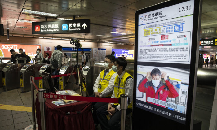 Le personnel du métro de Taipei, dans la station MRT, surveille la température des passagers à l'aide d'un scanner thermique à Taipei, Taïwan, le 16 mars 2020. (Paula Bronstein/Getty Images)(Photo by Paula Bronstein/Getty Images )