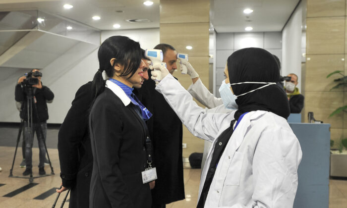 Du personnel médical égyptien prend la température corporelle des voyageurs à l'aéroport international du Caire le 1er février 2020. (AFP via Getty Images)
