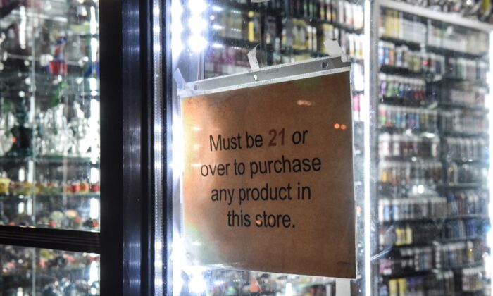 Une pancarte indiquant « doit avoir plus de 21 ans » est accrochée dans la vitrine d'un magasin de danse à New York le 19 décembre 2019. (Stephanie Keith/Getty Images)