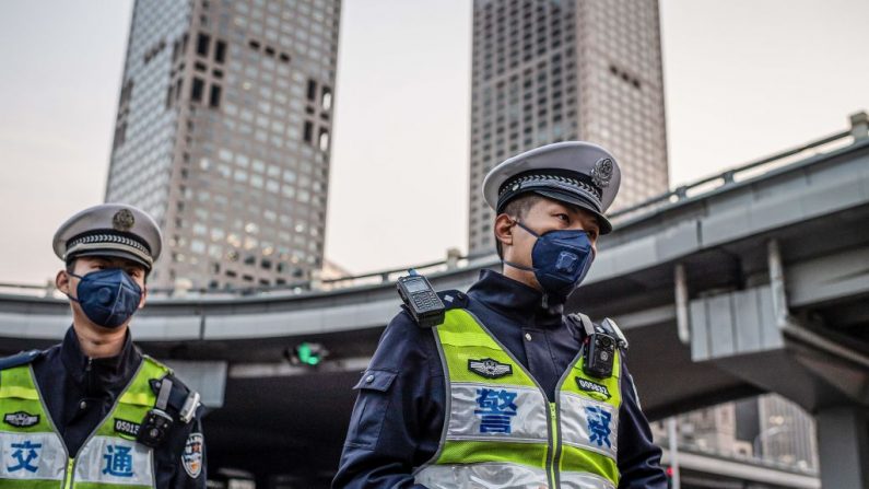 Des policiers masqués patrouillent dans une rue de Pékin le 7 avril 2020. (Nicolas Asfouri/AFP via Getty Images)