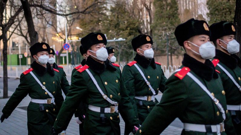 Police paramilitaire portant des masques faciaux alors qu'ils arpentent une rue de Pékin le 1er mars 2020. (Nicolas Asfouri/AFP via Getty Images)