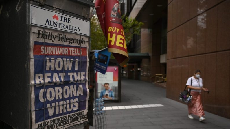Un gros titre de journal sur l'épidémie de coronavirus est visible dans une rue quasiment déserte de Sydney le 30 mars 2020. (PETER PARKS/AFP via Getty Images)