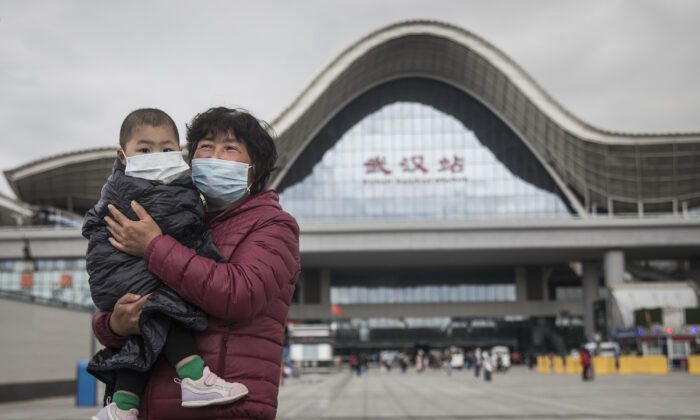 Une femme et son enfant arrivent à la gare de Wuhan, à Wuhan, dans la province du Hubei, en Chine, le 28 mars 2020. (Getty Images)