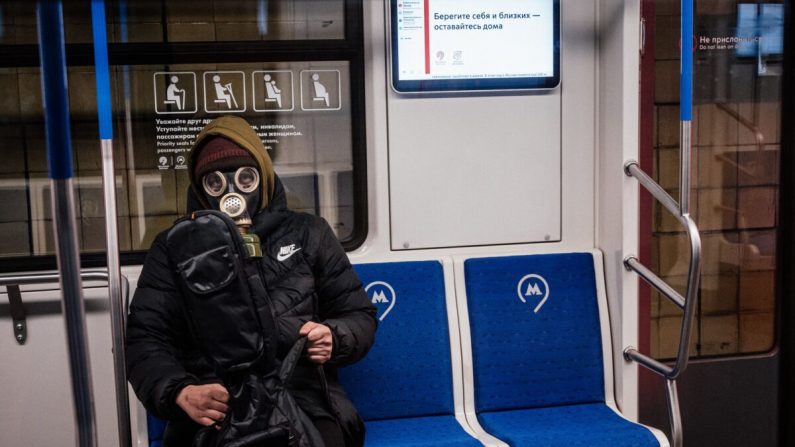 Un homme qui porte un masque à gaz est assis dans une rame du métro à Moscou le 31 mars 2020. (Dimitar Dilkoff/AFP via Getty Images)