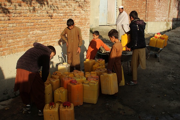 -Des garçons afghans remplissent les bidons d'eau potable d'un robinet dans la province de Khost le 20 novembre 2019. Photo de FARID ZAHIR / AFP via Getty Images.