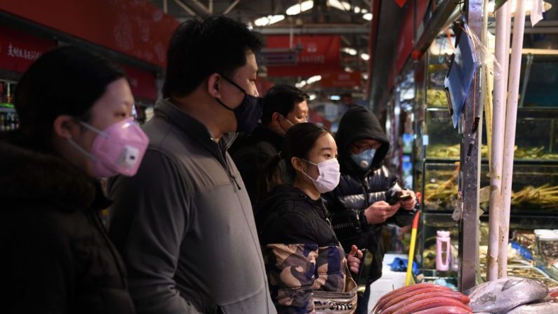 Des habitants portent des masques lorsqu'ils font leurs courses sur un marché de Pékin le 27 février 2020. (Greg Baker/AFP via Getty Images)