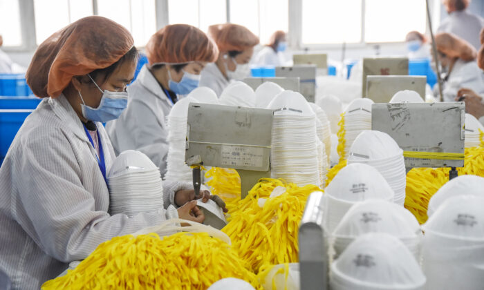 Des ouvriers fabriquent des masques dans une usine à Handan, en Chine, le 28 février 2020. (AFP via Getty Images)