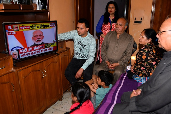 -Une famille regarde le discours du Premier ministre indien Narendra Modi à la nation sur un téléviseur à leur domicile à Amritsar le 24 mars 2020. Les 1,3 milliard de personnes en Inde seront soumises à la prolongation du "verrouillage total". Photo de NARINDER NANU / AFP via Getty Images.
