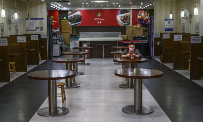Une Chinoise attend des clients dans un restaurant presque vide d'un centre commercial de Pékin, en Chine, le 26 mars 2020. (Kevin Frayer/Getty Images)