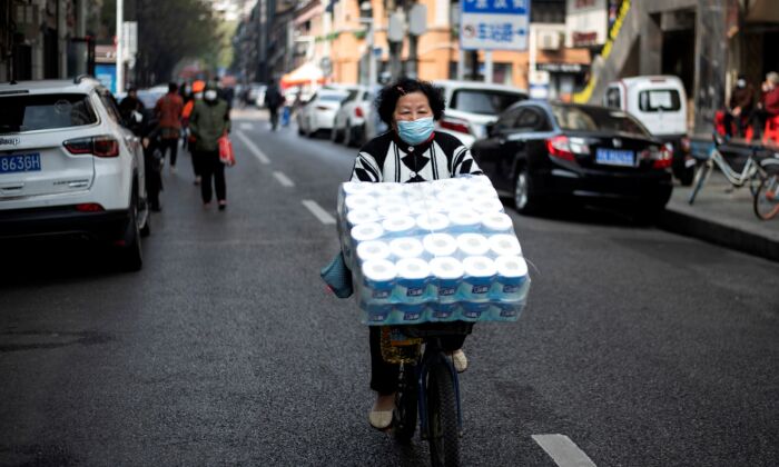 Une femme à vélo dans une rue de Wuhan en Chine, le 1er avril 2020. (Avec l'aimable autorisation de NOEL CELIS / AFP) (Avec l'aimable autorisation de NOEL CELIS/AFP via Getty Images)