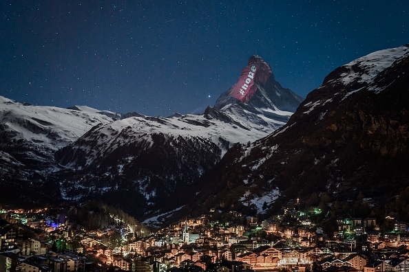 Le Cervin, montagne emblématique située à la frontière italo-suisse, qui culmine à 4 478 mètres, illuminée par l'artiste suisse Gerry Hofstetter en signe "d'espoir et de solidarité".  (Photo : FABRICE COFFRINI/AFP via Getty Images)