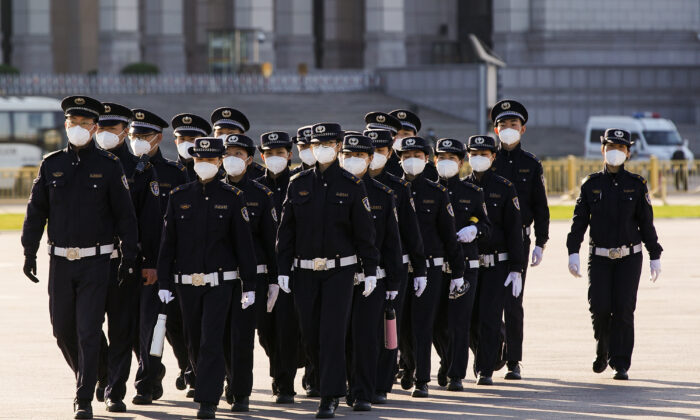 Des agents de sécurité chinois portant des masques de protection défilent sur la place Tiananmen à Pékin, en Chine, le 4 avril 2020. (Lintao Zhang/Getty Images)