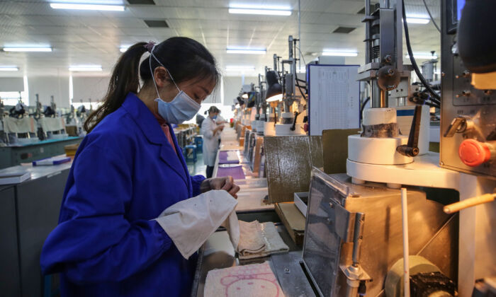Une employée travaille sur une chaîne de production photoélectrique dans une usine de Wuhan, en Chine, le 6 avril 2020. (STR/AFP via Getty Images)