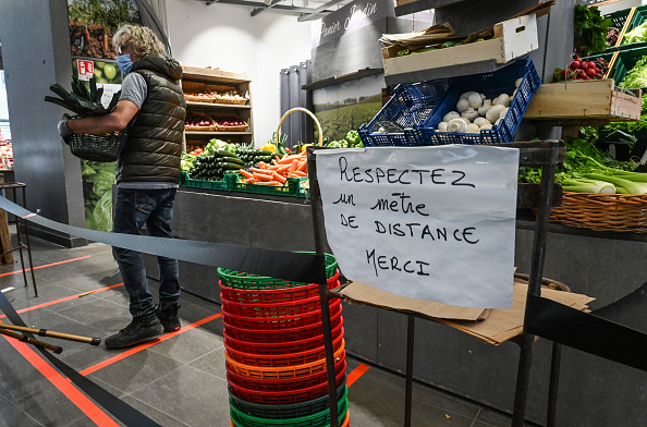 -Un employé portant un masque travaille près d'une pancarte indiquant "respectez une distance d'un mètre, merci" dans un marché couvert du centre de Montpellier le 7 avril 2020. Photo de Pascal GUYOT / AFP via Getty Images.