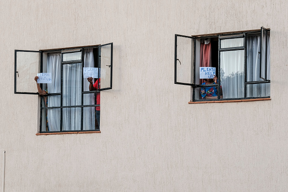 -Des personnes brandissent des pancartes demandant de l'aide après que le ministère de la Santé a prolongé illégalement la période de détention des personnes en quarantaine à 28 jours dans une installation de quarantaine désignée par le gouvernement à Nairobi le 04 avril 2020. Photo par - / AFP via Getty Images.